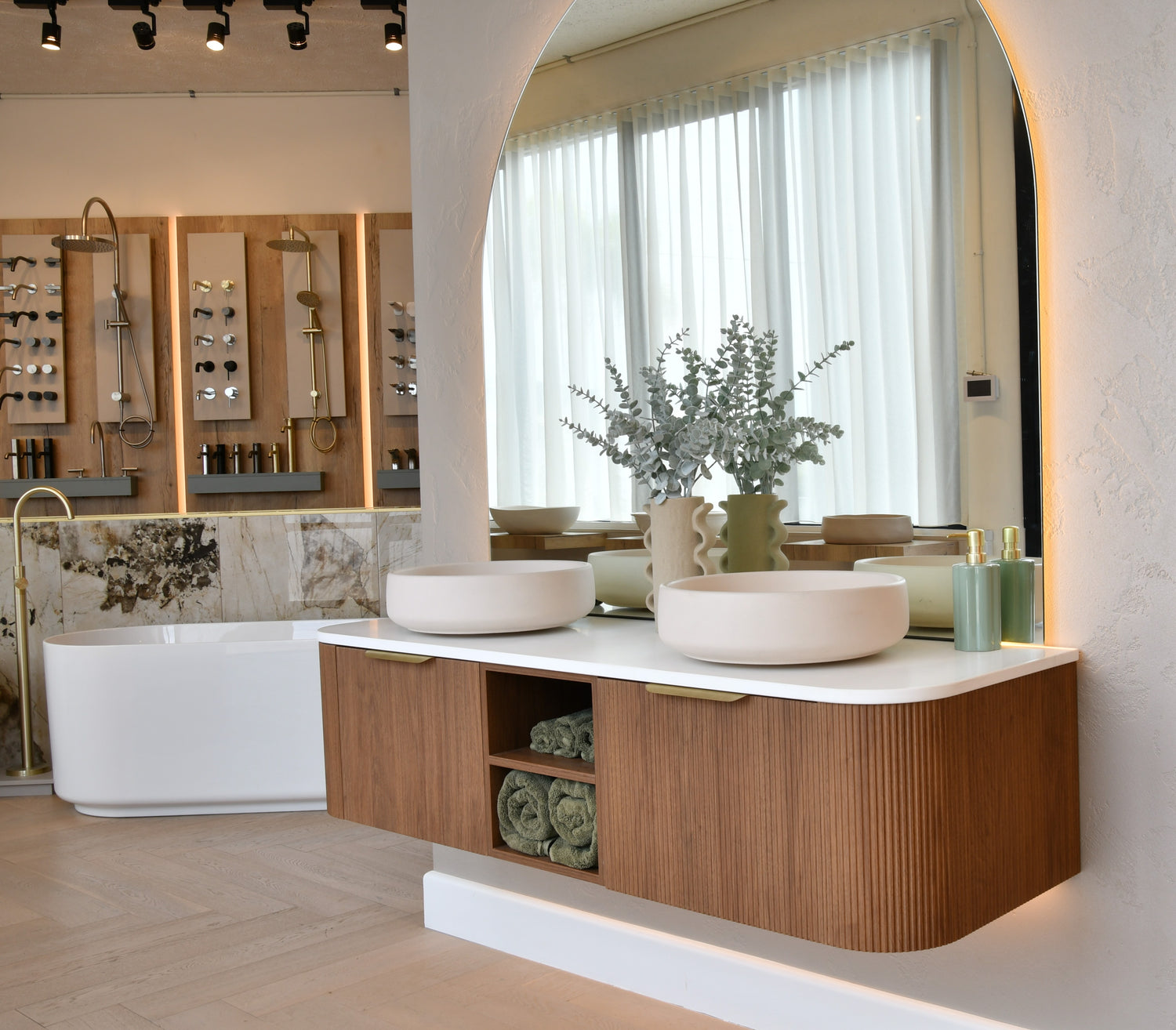 Modern bathroom interior with wooden vanity, white sink, and bathtub.